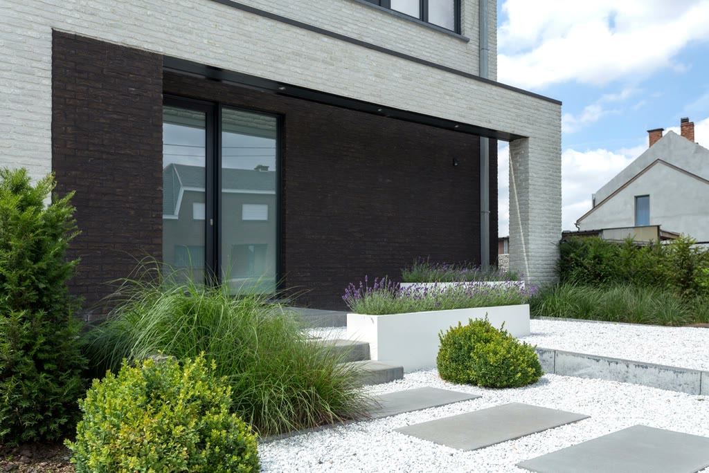Fachada de casa contemporanea com jardim de pedras e grama